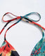 Chiffon maxi beach dress with halter neckline, ditsy floral print, split thigh, and tie-back with chain and ring details